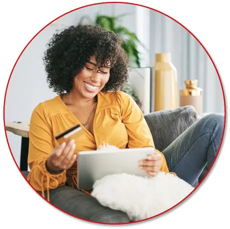 a women in yellow on the couch doing online shopping from a tablet