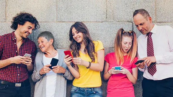 Group of four different ages people with smart phones outdoors, registering for the Marketing to Each Generation webinar