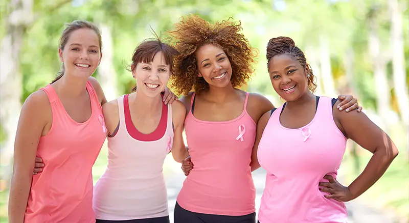 group of women wearing pink posing for a photo before a non-profit charity run