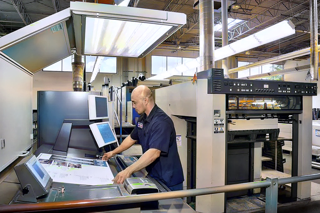 Press operator working on a printing press for direct mail postcards