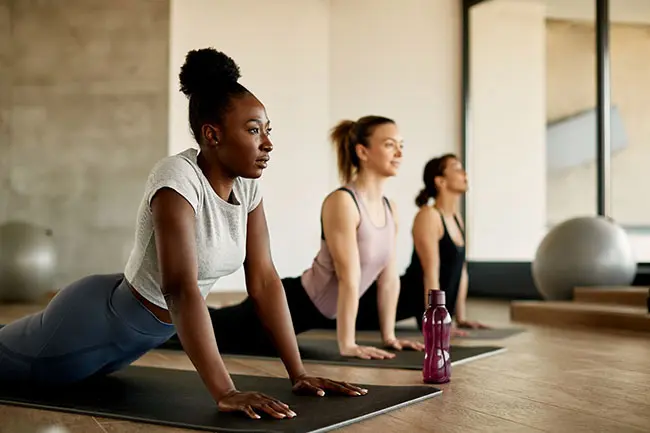 Three females practicing yoga on a yoga mats